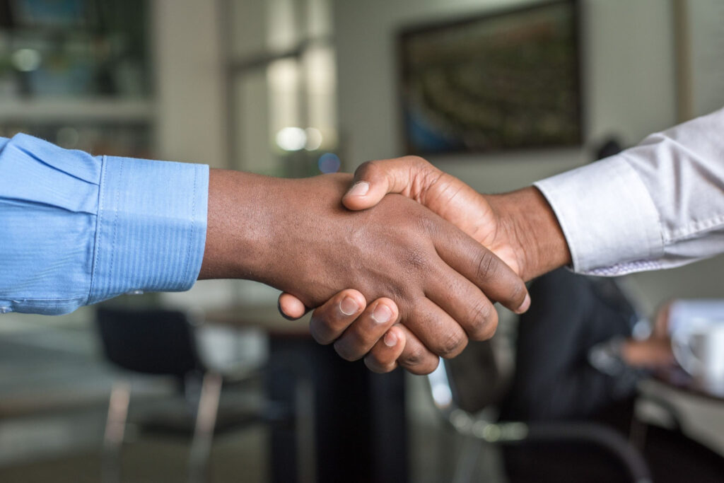 Two individuals shaking hands after establishing trust through LegitScript Certification.